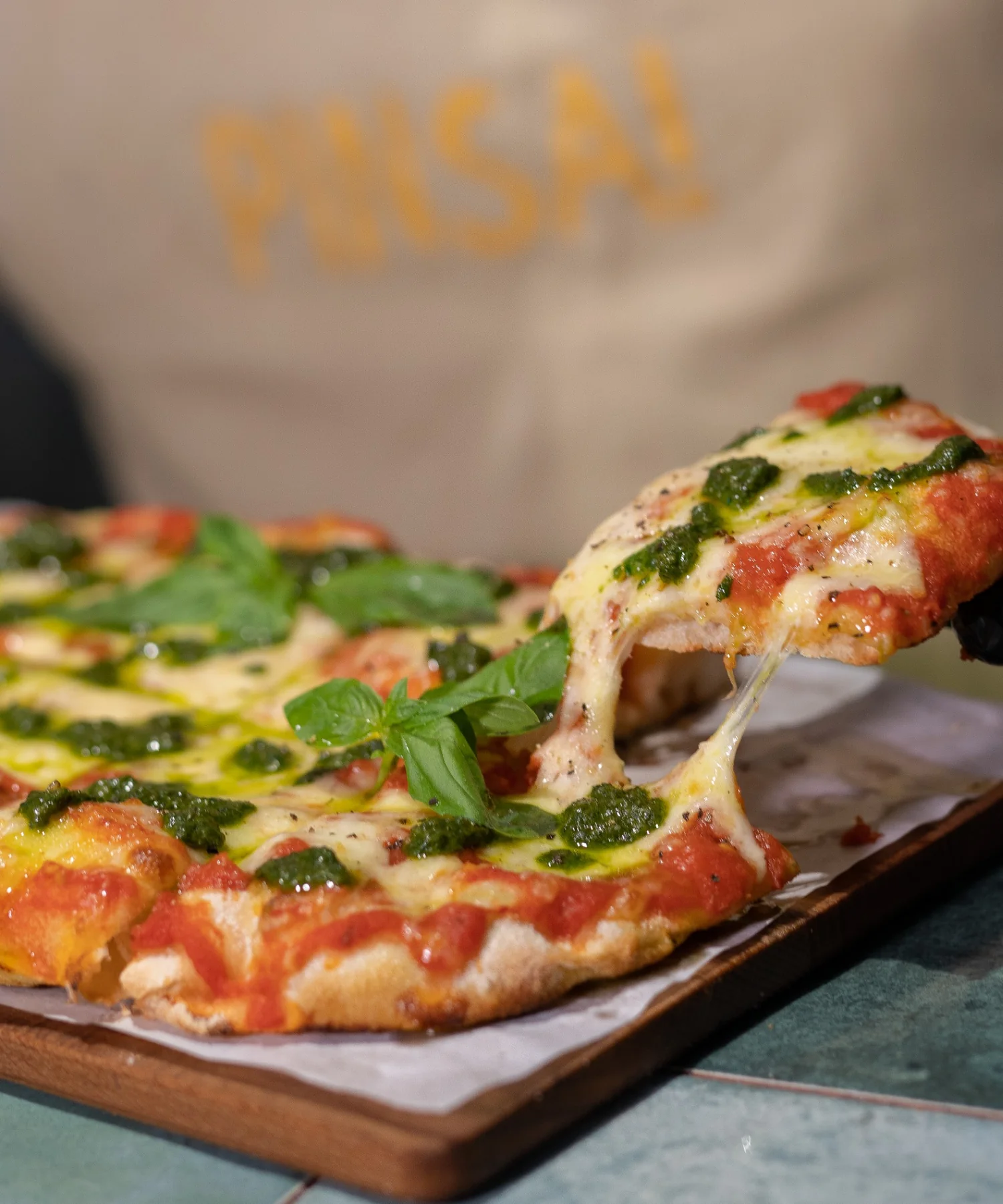 Fresh pinsa with tomatoes, melted cheese and basil